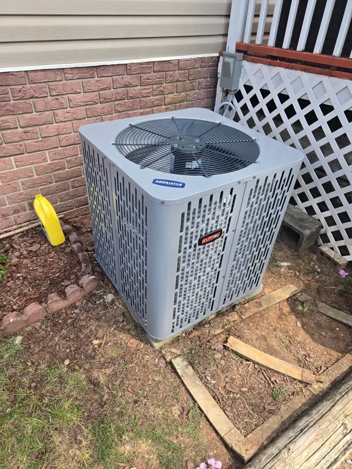 New Ameristar air conditioner condenser installed beside a home