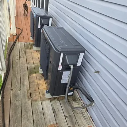 Two ductless mini-split outdoor units installed on a wooden deck